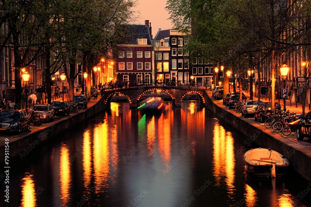 Canals of Amsterdam with bridge lit at night, Netherlands