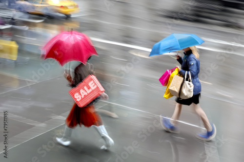 people shopping in the cityin rainy weather motion blur