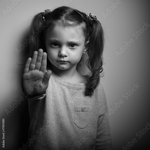 Stop violence against kids. Serious kid showing hand stop sign.