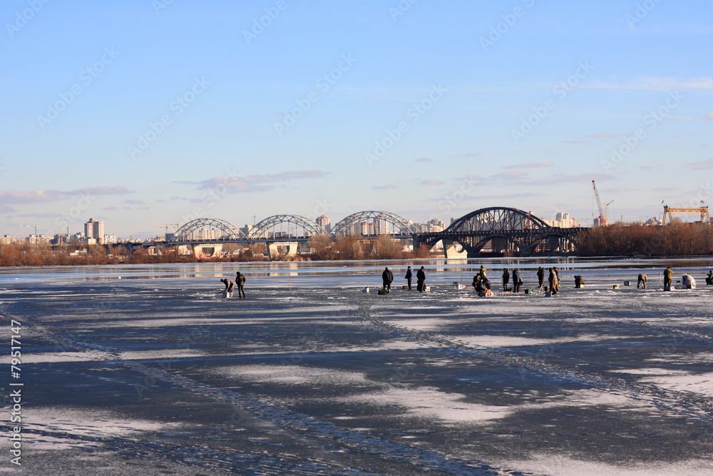 Fishermen sit on the ice of the river Dnieper in Kiev, Ukraine