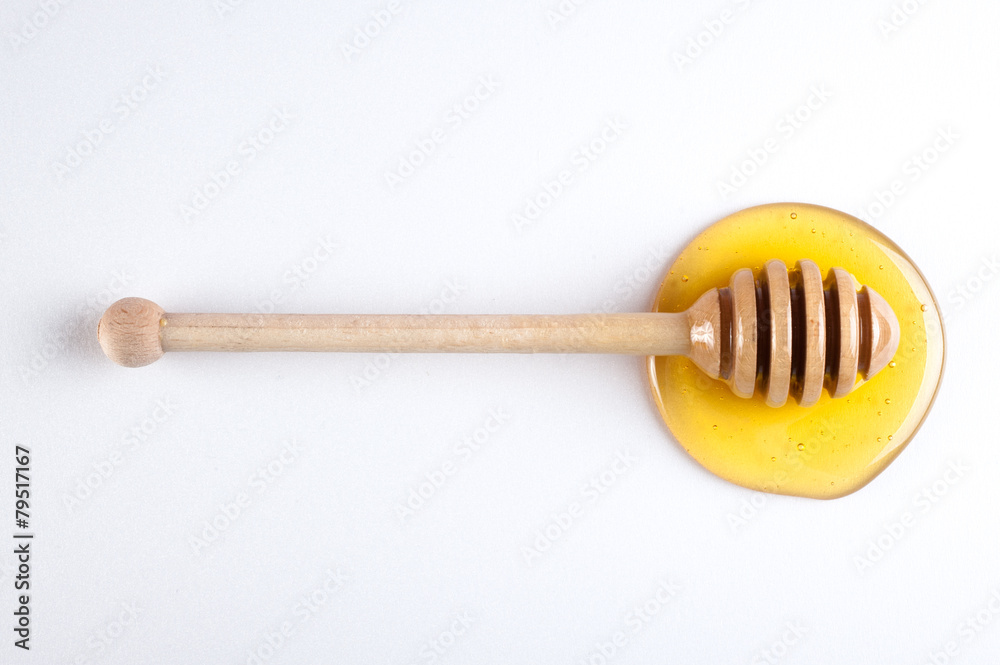 honey flowing down from a wooden stick isolated on white honey flowing down from a wooden stick isolated on white
