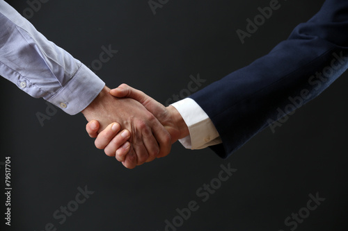 Business handshake on dark background © Africa Studio