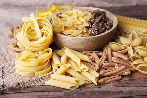 Different types of pasta on rustic wooden table