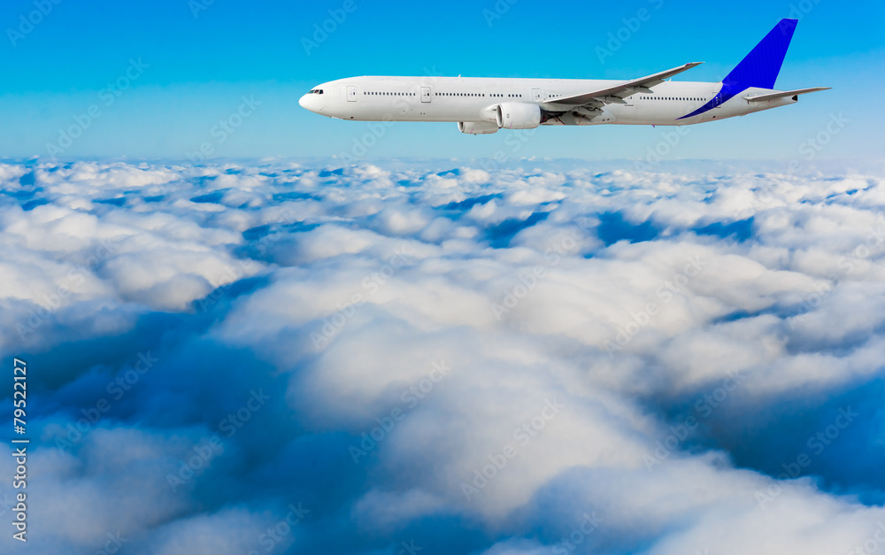 Fototapeta premium Passenger airplane flying above dramatic clouds