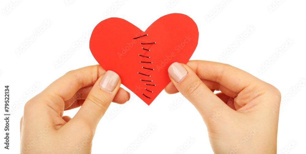 Female hands holding broken heart stitched isolated on white Female hands holding broken heart stitched isolated on white