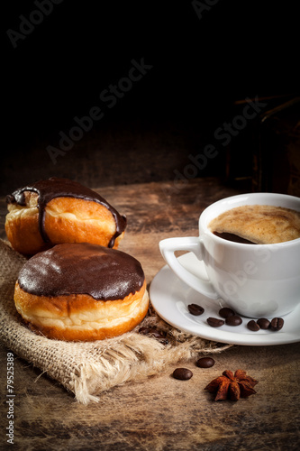 Donuts with coffee cup served on wooden table