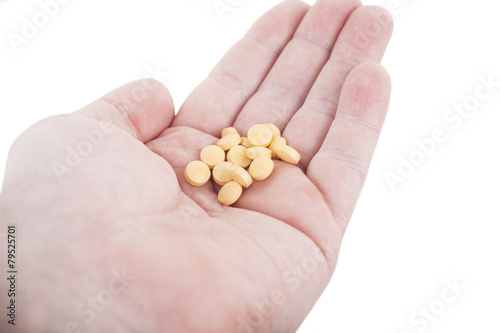 Hand holding yellow pills