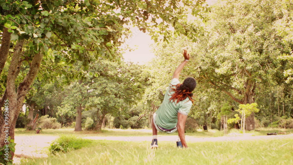 Young break dancer doing back flip in the park Young break dancer doing back flip in the park