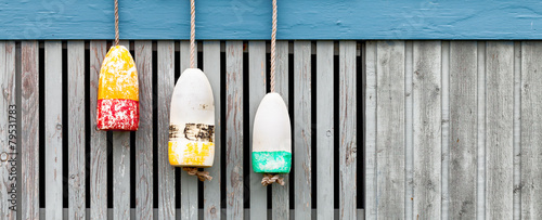 lobster buoys on weathered wood fence. Banner format