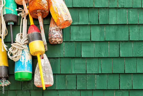 Lobster buoys hanging on a green shingled wall photo