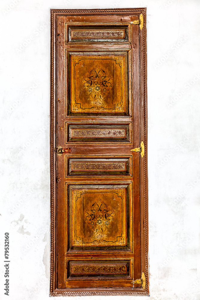 Moroccan antique painted door in a white plaster wall Moroccan antique painted door in a white plaster wall