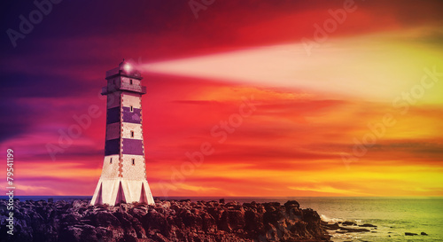 Seascape with lighthouse at sunset, color toning applied.