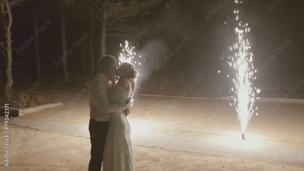 Newlyweds kissing under the fireworks in the street Newlyweds kissing under the fireworks in the street