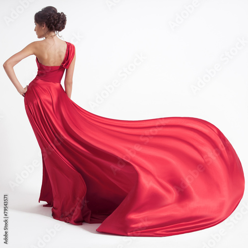Fotografía Young beauty woman in fluttering red dress. White background.