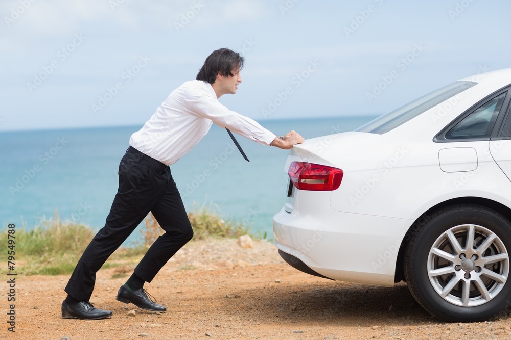 Businessman pushing his car
