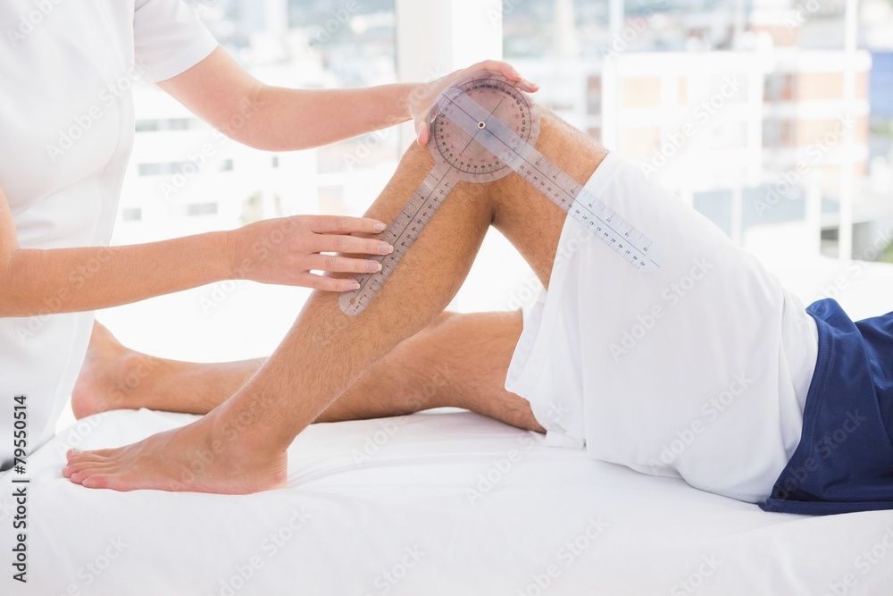 Fototapeta premium Doctor examining man leg