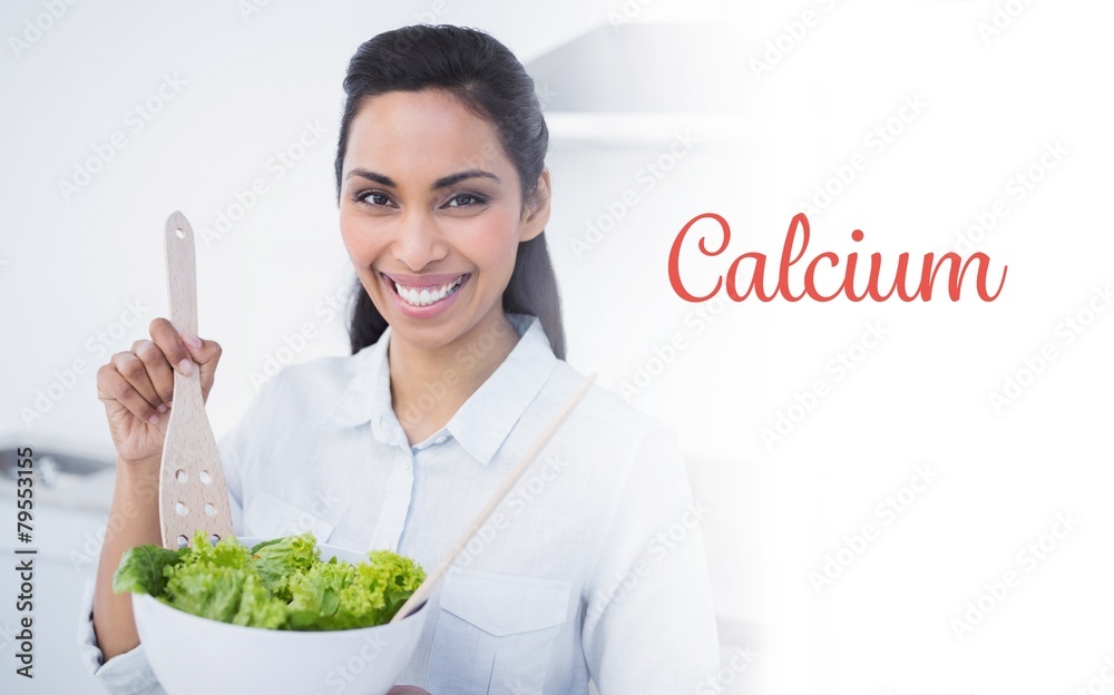 Calcium against beautiful smiling woman showing salad Calcium against beautiful smiling woman showing salad