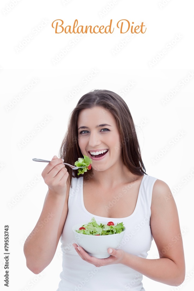 Balanced diet against smiling young woman eating a salad Balanced diet against smiling young woman eating a salad