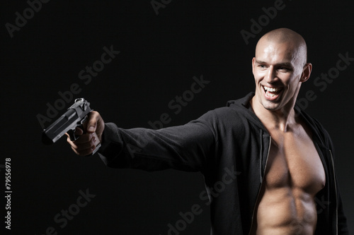 evil smiling man shooting gun isolated on black background
