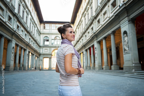 Young woman standing near uffizi gallery in florence, italy photo