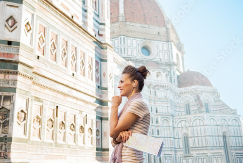 Fotografi Happy young woman with map and audio guide in firenze