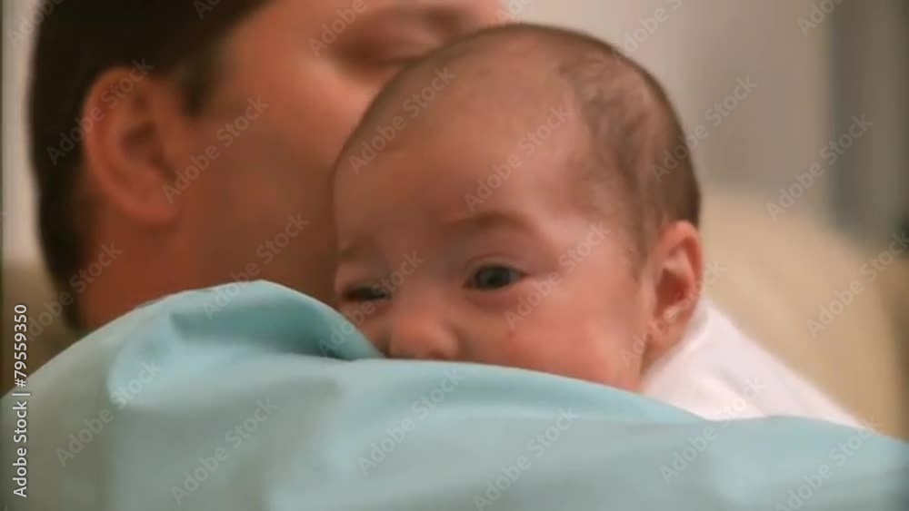 A two month old infant and it's father. A two month old infant and it's father.