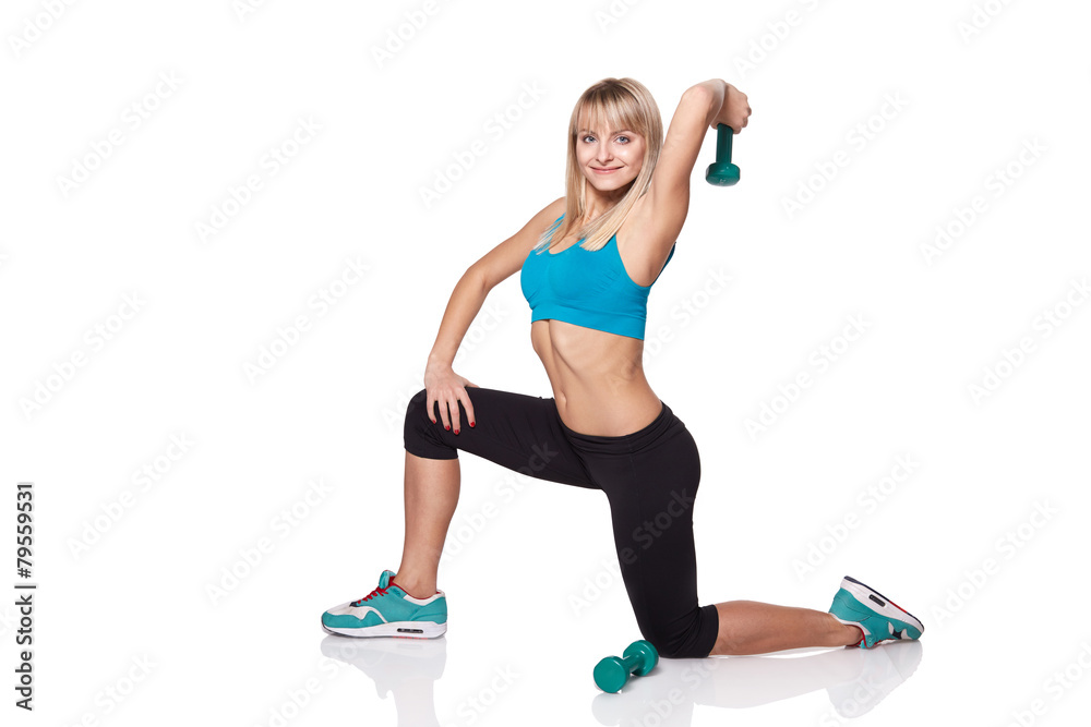 Young woman smiling while using dumbbells against a white backgr Young woman smiling while using dumbbells against a white backgr
