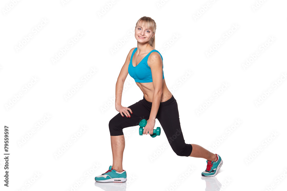 Young woman smiling while using dumbbells against a white backgr
