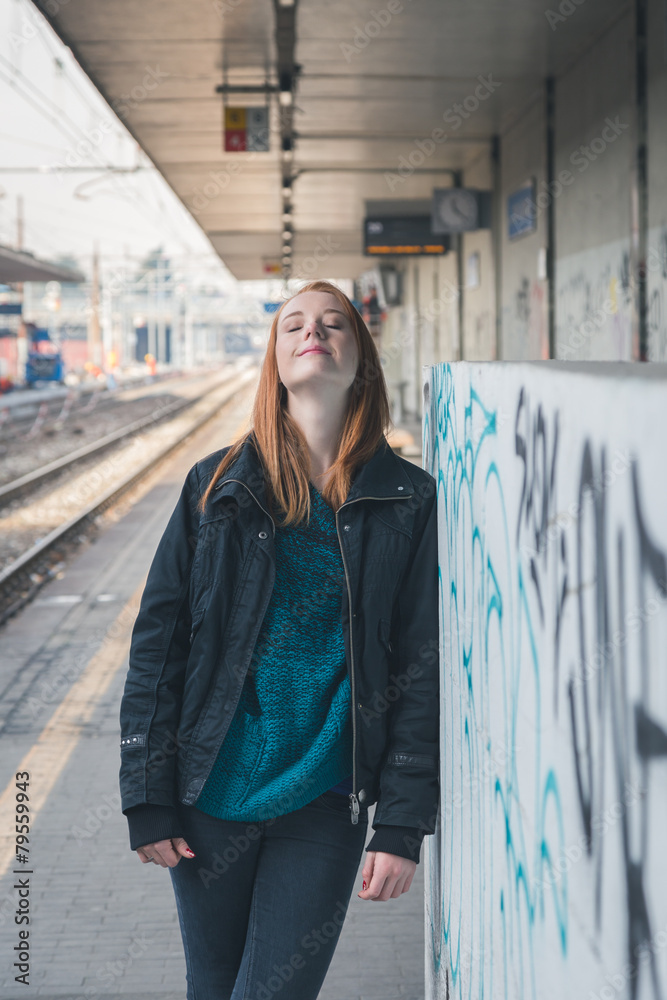 Beautiful girl posing in a railroad station