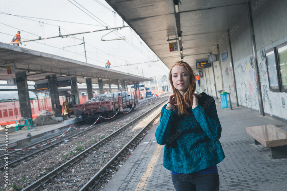 Beautiful girl posing in a railroad station