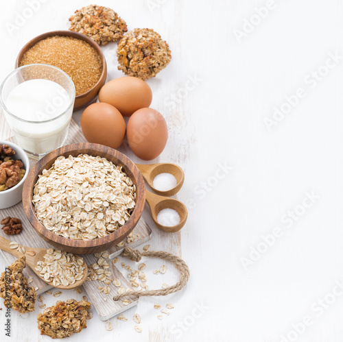 oat flakes and ingredients for making cookies on white table