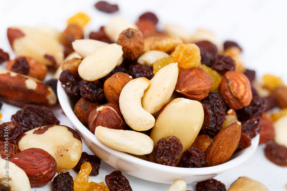 Mixed nuts and sultanas on a plate on a white background Mixed nuts and sultanas on a plate on a white background