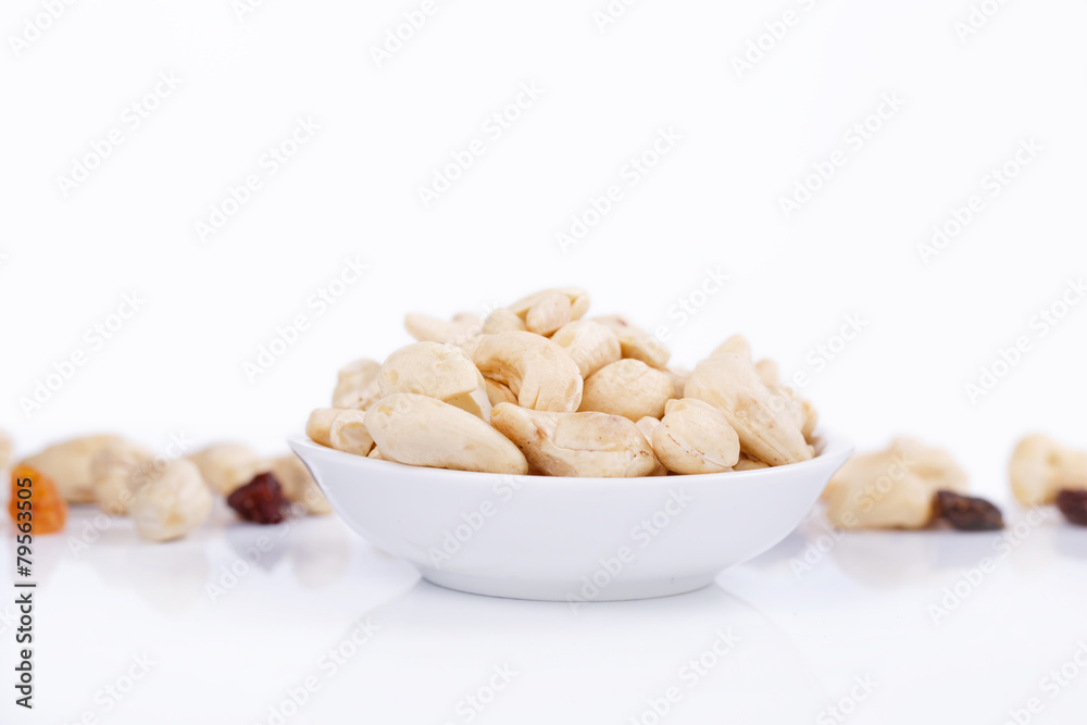 Cashew nuts with sultanas on plate isolated on the white backgro Cashew nuts with sultanas on plate isolated on the white backgro