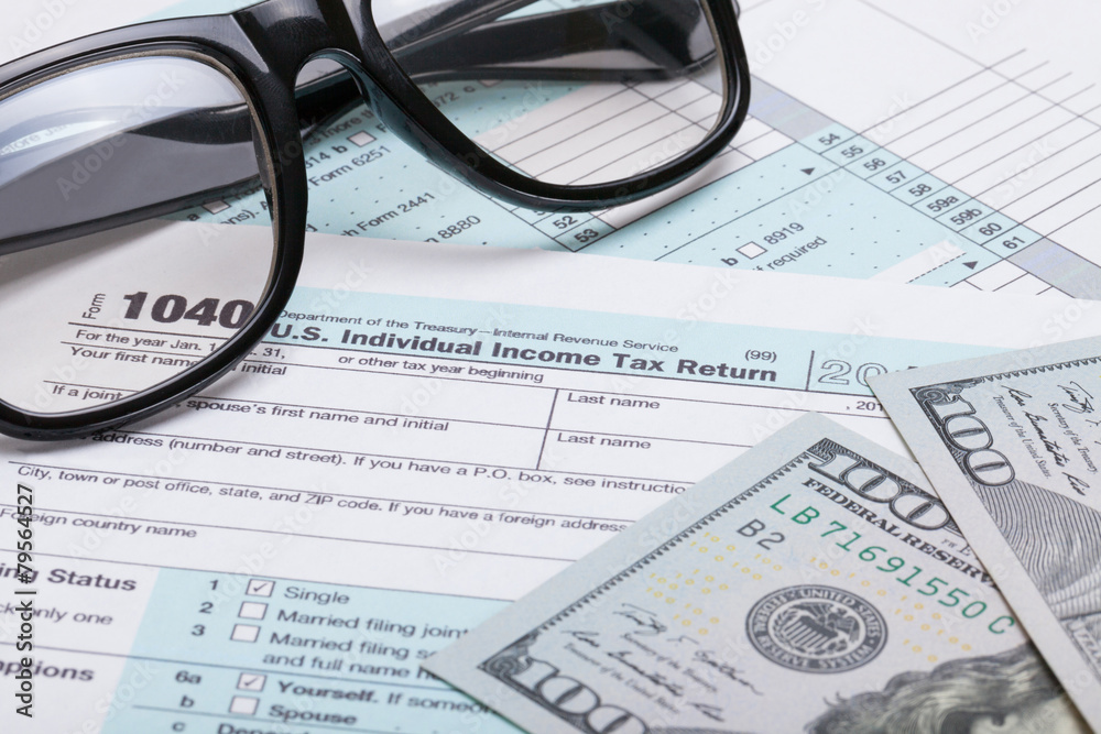 US 1040 Tax Form, glasses and dollars - studio shot US 1040 Tax Form, glasses and dollars - studio shot