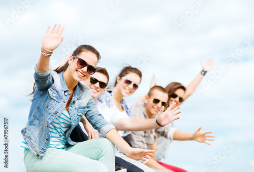 group of teenagers waving hands © Syda Productions