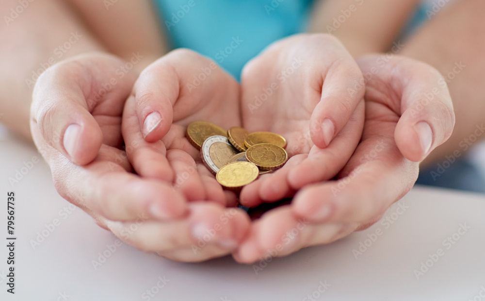 close up of family hands holding euro money coins close up of family hands holding euro money coins