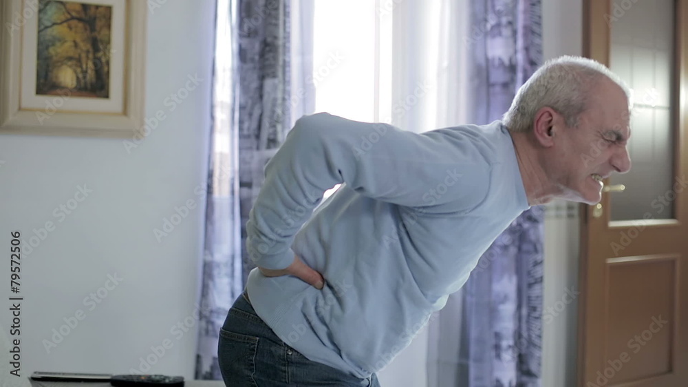 old man getting up from the sofa feeling back pain - backache