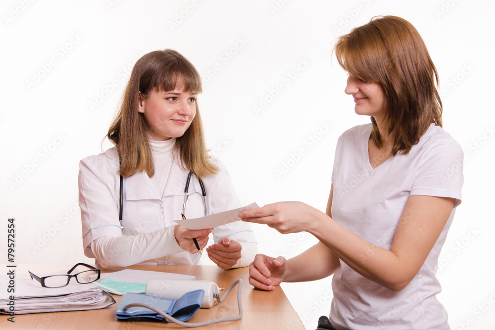 Physician in office extends topatient a prescription Physician in office extends topatient a prescription