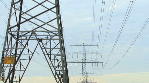 Zoom out on electricy pylon and powercables at sunset photo