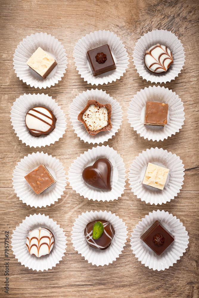 Top view on assorted chocolate pralines on wood