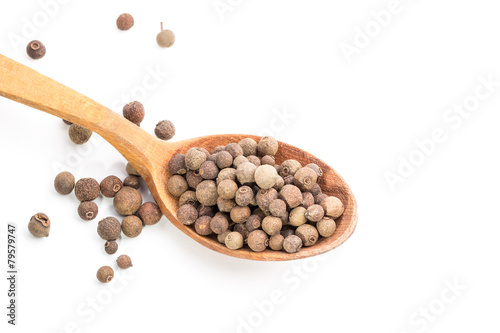 Aromatic allspice in wooden spoon. Isolated