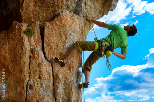 Rock climber climbing up a cliff
