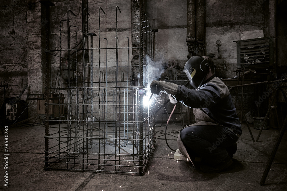 Welder with protective mask welding reinforcement bars - obrazy, fototapety, plakaty 
