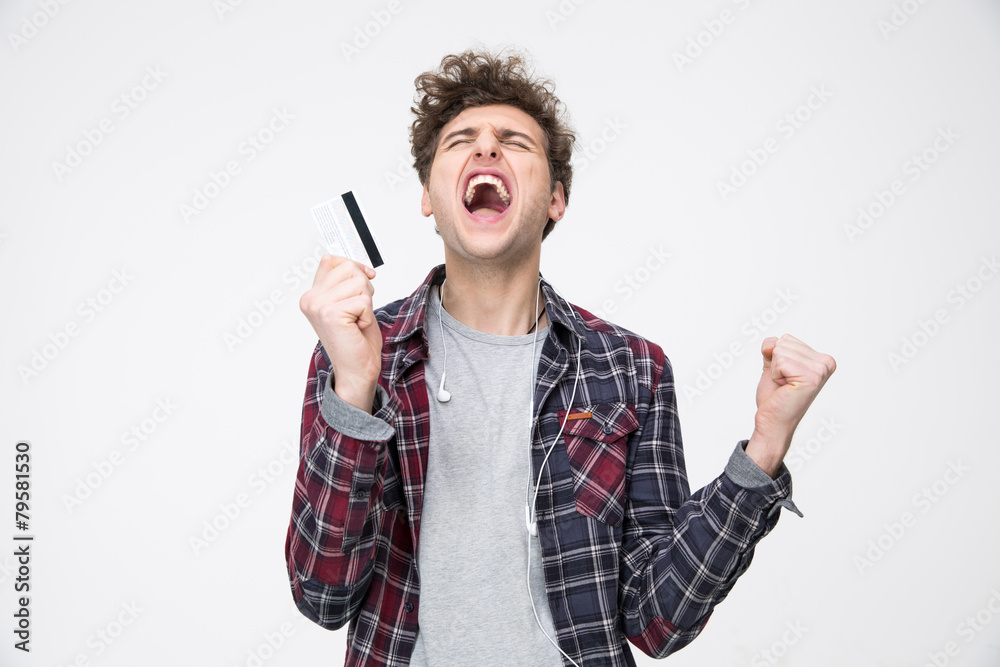 Young casual man standing with credit card and shouting Young casual man standing with credit card and shouting