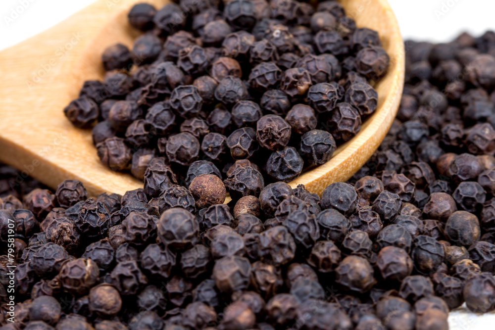 closeup black pepper in wooden spoon on fabric closeup black pepper in wooden spoon on fabric