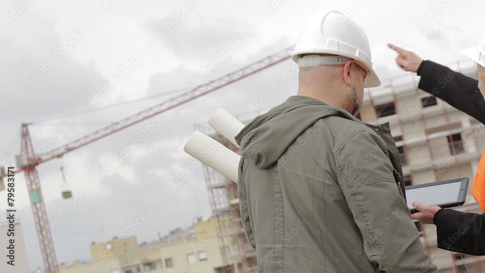 Architect and engineer looking at plan on construction site