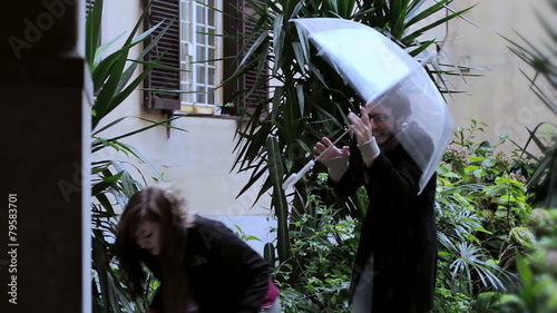 nerdy man almost knocks his girl with umbrella photo