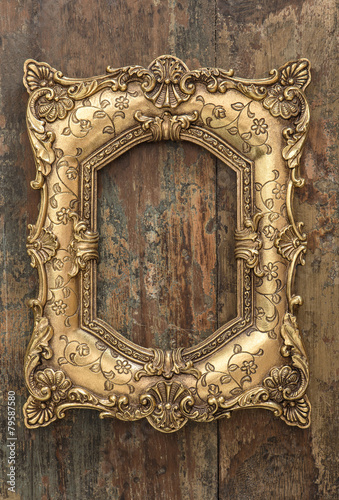 Vintage golden frame on wooden background. Grunge texture