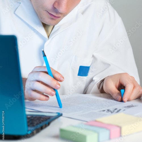 Canvas Print Young scientist reads fresh publication