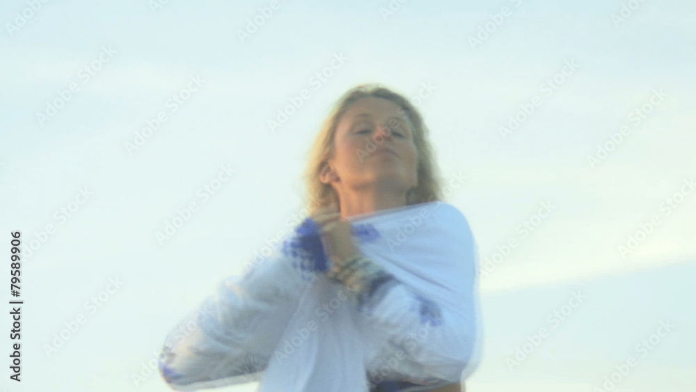 MS OF A YOUNG WOMAN PUTTING ON A  HOODIE